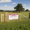 a farm biosecurity sign installed on a gate.