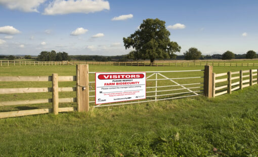 a farm biosecurity sign installed on a gate.